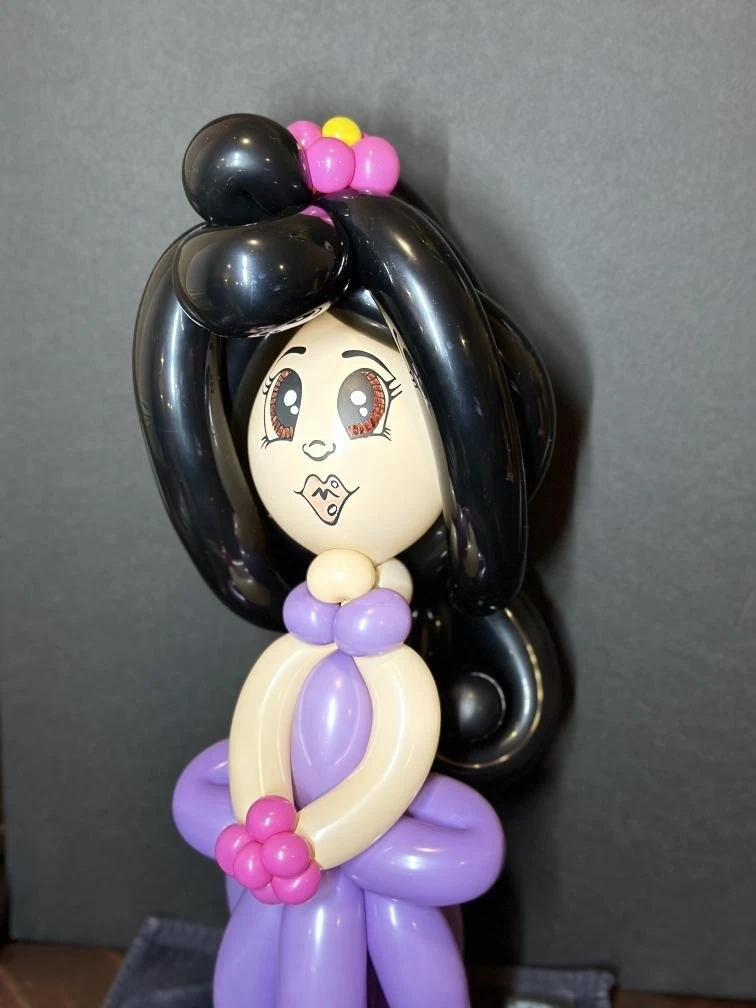Handmade balloon character with black hair and purple dress