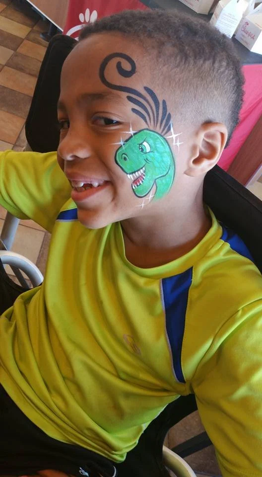 Green dinosaur face painting on a child